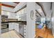 Bright kitchen with white cabinets, granite countertops, stainless steel appliances and views of the living room at 2665 Sequoia Ter # 306, Palm Harbor, FL 34683