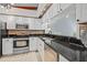 Modern kitchen featuring stainless steel appliances, white cabinets, and granite counters at 2665 Sequoia Ter # 306, Palm Harbor, FL 34683