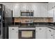 Modern kitchen features stainless steel appliances, granite counters, and white cabinetry at 2665 Sequoia Ter # 306, Palm Harbor, FL 34683