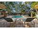 Community pool surrounded by mature trees, shade umbrellas, cabana, lounge chairs and tables at 2665 Sequoia Ter # 306, Palm Harbor, FL 34683