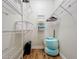 Organized walk-in closet with white wire shelving, a laundry basket, folded towels, a shredder, and an accent cushion at 2724 Via Murano # 615, Clearwater, FL 33764