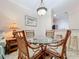 Cozy dining area with a glass-top table, wicker chairs, and a view into the kitchen at 2724 Via Murano # 615, Clearwater, FL 33764