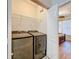 A functional laundry room with front-load washer and dryer and a view to the bedroom through the open doorway at 2724 Via Murano # 615, Clearwater, FL 33764
