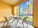 Relaxing screened patio with seating area, offering a pleasant view of the surrounding landscape and parked vehicles at 2724 Via Murano # 615, Clearwater, FL 33764