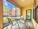 Cozy screened patio with outdoor seating, providing a view of the complex, landscaping, and parked cars at 2724 Via Murano # 615, Clearwater, FL 33764