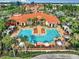 Aerial view of a luxurious pool area with lounge chairs, umbrellas, and tropical landscaping at 2724 Via Murano # 615, Clearwater, FL 33764