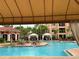 Stunning pool area with crystal-clear water, lounge chairs, cabanas, lush landscaping, and a glimpse of the surrounding building at 2724 Via Murano # 615, Clearwater, FL 33764