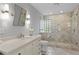 Well-lit bathroom with dual sinks, a glass-enclosed shower, and neutral color scheme at 2817 Seabreeze S Dr, Gulfport, FL 33707