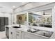 Well-lit kitchen with stainless steel appliances, granite countertops and an island cooktop at 2817 Seabreeze S Dr, Gulfport, FL 33707