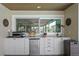 Outdoor kitchen with a mini fridge, grill, sink, and storage at 2817 Seabreeze S Dr, Gulfport, FL 33707