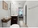 A half bathroom featuring white walls and wood-look tile floors with an adjacent bedroom at 2874 Deer Pine Trl, Land O Lakes, FL 34638
