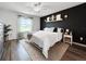 A beautifully staged bedroom featuring modern decor, a striking accent wall and wood flooring at 2874 Deer Pine Trl, Land O Lakes, FL 34638