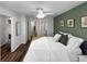 Relaxing bedroom featuring hardwood floors, a ceiling fan, and olive green accent wall at 2874 Deer Pine Trl, Land O Lakes, FL 34638