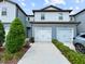 Street view of a two-story townhome with a white garage door and blue siding at 2874 Deer Pine Trl, Land O Lakes, FL 34638