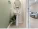 Stylish powder room features pedestal sink and a decorative mirror and plant at 2874 Deer Pine Trl, Land O Lakes, FL 34638