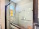 Close up of blue tiled shower with glass enclosure and stainless shower head and fixtures at 2912 Case Ave, Bradenton, FL 34207