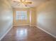 Bright bedroom featuring wood floors, a ceiling fan, and a window with blinds at 3002 W Cleveland St # C3, Tampa, FL 33609