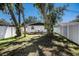 Spacious backyard with mature trees, grassy lawn, wooden deck and privacy fence at 3019 Park N St, St Petersburg, FL 33710