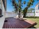 Charming backyard with wood deck, seating area, mature trees, and white privacy fence at 3019 Park N St, St Petersburg, FL 33710
