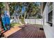 Inviting backyard with a wood deck, outdoor seating, lush trees, and privacy fence at 3019 Park N St, St Petersburg, FL 33710