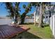 Cozy backyard with wood deck, mature trees, seating area, and a white privacy fence at 3019 Park N St, St Petersburg, FL 33710