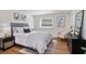 Comfortable bedroom with a gray upholstered bed, decorative art, and a well-lit window at 3019 Park N St, St Petersburg, FL 33710
