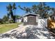 The charming home has black and white exterior paint, complimented by green grass and mature trees at 3019 Park N St, St Petersburg, FL 33710
