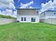 The backyard features a grass lawn, sliding glass door, and white vinyl fencing at 34056 Scarlet Sage Ct, Wesley Chapel, FL 33545