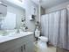 This clean and modern bathroom has a shower with white curtain and an undermount sink at 34056 Scarlet Sage Ct, Wesley Chapel, FL 33545