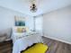 Bright bedroom with a large bed, modern decor, hardwood floors, and a sunny yellow rug at 34056 Scarlet Sage Ct, Wesley Chapel, FL 33545