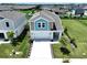 Two-story home boasts a well-maintained lawn, pristine driveway, and a charming blue and gray exterior at 34056 Scarlet Sage Ct, Wesley Chapel, FL 33545