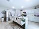 Modern kitchen with a center island, sleek white cabinetry, stainless steel appliances and stylish bar stools at 34056 Scarlet Sage Ct, Wesley Chapel, FL 33545