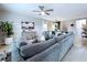 Spacious living room showcases a large gray sectional sofa, a mounted TV, and light wood-style floors at 34056 Scarlet Sage Ct, Wesley Chapel, FL 33545