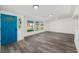 Bright living room featuring wood flooring, large windows, and a blue front door at 3614 Vasco St, Punta Gorda, FL 33950
