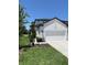 A two-car garage complements the facade of this modern home with immaculate landscaping at 3719 Nandina Cir, Sun City Center, FL 33573