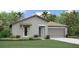 Inviting single-story home featuring a well-manicured lawn, complemented by an attached two-car garage and lush tropical landscaping at 4015 86Th E St, Palmetto, FL 34221