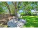 Private backyard featuring a modern fire pit surrounded by four pink chairs and lush landscaping at 4019 W Bay To Bay Blvd, Tampa, FL 33629