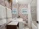 Cozy bathroom with botanical wallpaper, a modern vanity, and a shower-tub combo with marble tile at 4019 W Bay To Bay Blvd, Tampa, FL 33629