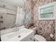 Bathroom featuring elegant botanical wallpaper, a modern vanity, and a shower with marble tile at 4019 W Bay To Bay Blvd, Tampa, FL 33629