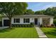 Charming single-story home with manicured lawn and mature trees under a clear blue sky at 4019 W Bay To Bay Blvd, Tampa, FL 33629