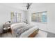 Bright bedroom with bed, two windows, ceiling fan, and stylish side tables at 410 73Rd Ave, St Pete Beach, FL 33706