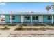 Charming turquoise home with a covered porch and white support columns, offering a relaxed, coastal living vibe at 410 73Rd Ave, St Pete Beach, FL 33706
