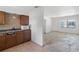 View of the kitchen with wooden cabinets open to the house's empty living room at 410 73Rd Ave, St Pete Beach, FL 33706