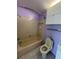 Standard bathroom featuring a tub and toilet, in neutral colors with storage at 4148 Dolphin Dr # 3, Tampa, FL 33617