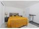 Bedroom with a golden bedspread, wood-look floors, a treadmill, and ample natural light at 4150 Woodsville Dr, New Port Richey, FL 34652