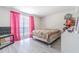 Bright bedroom with gray wood-look floors and large window, filled with pink curtains for a colorful touch at 4150 Woodsville Dr, New Port Richey, FL 34652