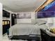 Comfortable bedroom with decorative artwork, flatscreen tv, side table, and modern gray wood-look floors at 4150 Woodsville Dr, New Port Richey, FL 34652