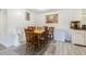 Inviting dining area featuring a wooden table with chairs, next to a breakfast bar and a view into the kitchen at 4150 Woodsville Dr, New Port Richey, FL 34652