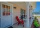 Inviting front porch with red chairs, white columns, and tile floor for relaxing outdoors at 4150 Woodsville Dr, New Port Richey, FL 34652