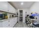 Bright kitchen with white cabinets, granite countertops, stainless steel appliances, and wood-look floors at 4150 Woodsville Dr, New Port Richey, FL 34652